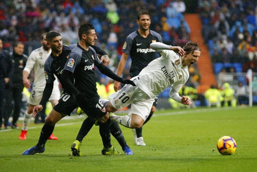 Pemain Real Madrid Luka Modric (putih) diganjal para pemain Sevilla.