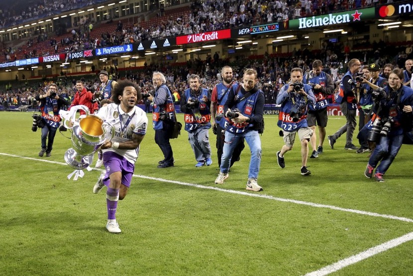 Pemain Real Madrid Marcelo merayakan kemenangan timnya di final Liga Champions melawan Juventus, Sabtu (3/6).