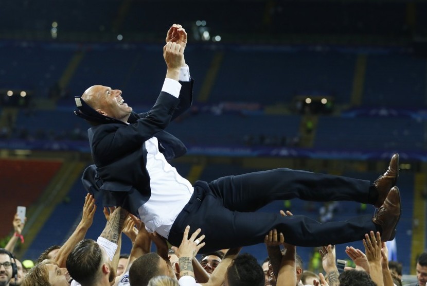 Pemain Real Madrid mengangkat pelatih Zinedine Zidane setelah mereka merayakan kemenangannya di Liga Champions, Ahad (29/5).