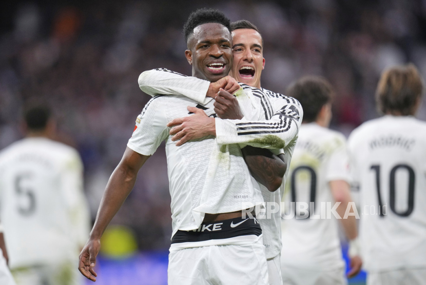 Pemain Real Madrid Vinicius Junior merayakan golnya bersama rekan setimnya Lucas Vazquez setelah mencetak gol kedua bagi timnya dalam pertandingan La Liga Spanyol melawan Rayo Vallecano di stadion Santiago Bernabeu di Madrid, Spanyol, Ahad, 9 Maret 2025