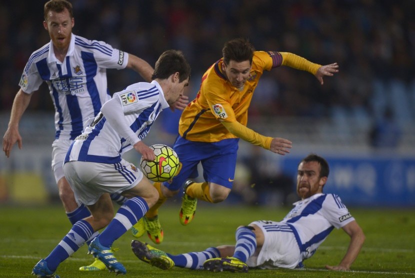 Pemain Real Sociedad Aritz Elustondo serta Mikel Gonzales saat beradu dengan pemain Barcelona Lionel Messi, Ahad (10/4).