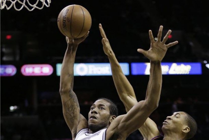 Pemain San Antonio Spurs, Kawhi Leonard (kiri), berebut bola dengan pemain Phoenix Suns, Wesley Johnson, di laga NBA di San Antonio pada Rabu (27/2). 