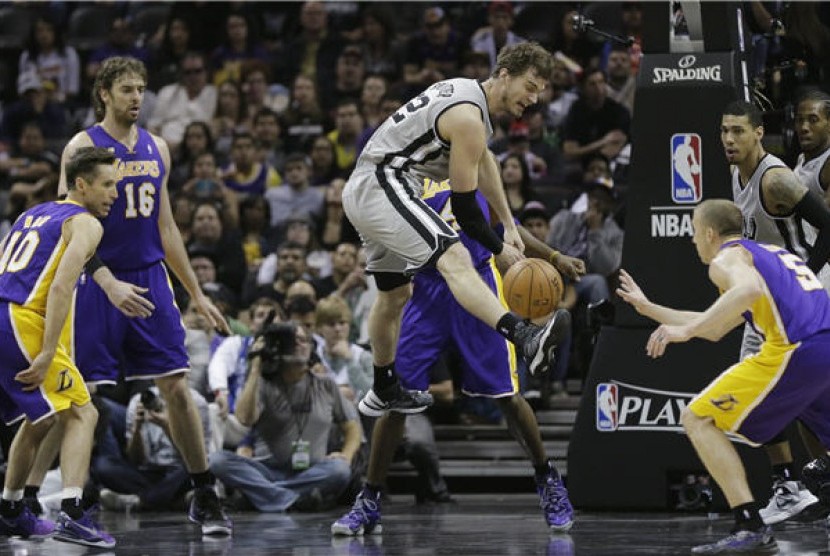 Pemain San Antonio Spurs, Tiago Splitter (tengah), kehilangan bola di tengah kepungan pemain Los Angeles Lakers di laga playoff NBA di San Antonio, Texas, Rabu (24/4). 
