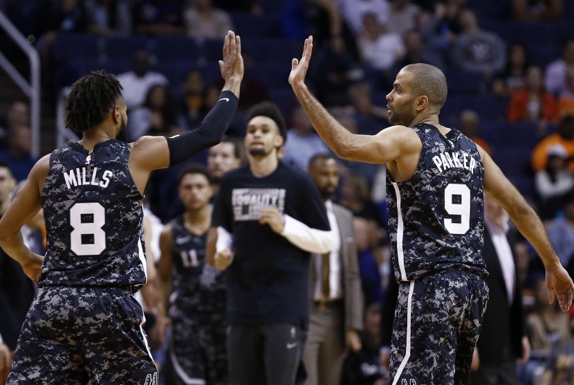 Pemain San Antonio Spurs, Tony Parker (kanan) dan Patty Mills, melakukan selebrasi high-five after usai mencetak poin saat menghadapi Phoenix Sun dalam pertandingan basket NBA di Phoenix pada Rabu (7/2). 