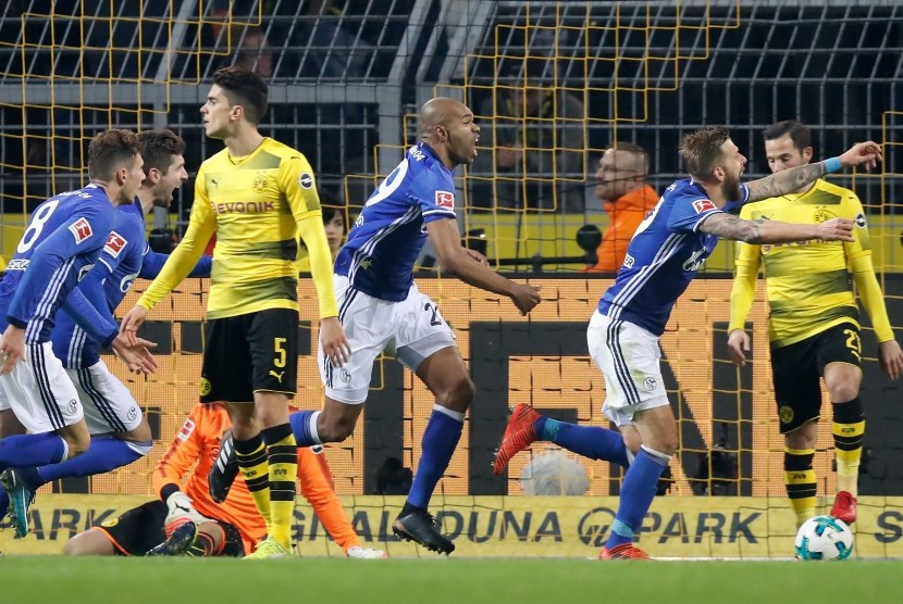 Pemain Schalke Naldo (tengah) merayakan gol ke gawang Borussia Dortmund pada pertandingan Bundesliga, Sabtu (25/11).