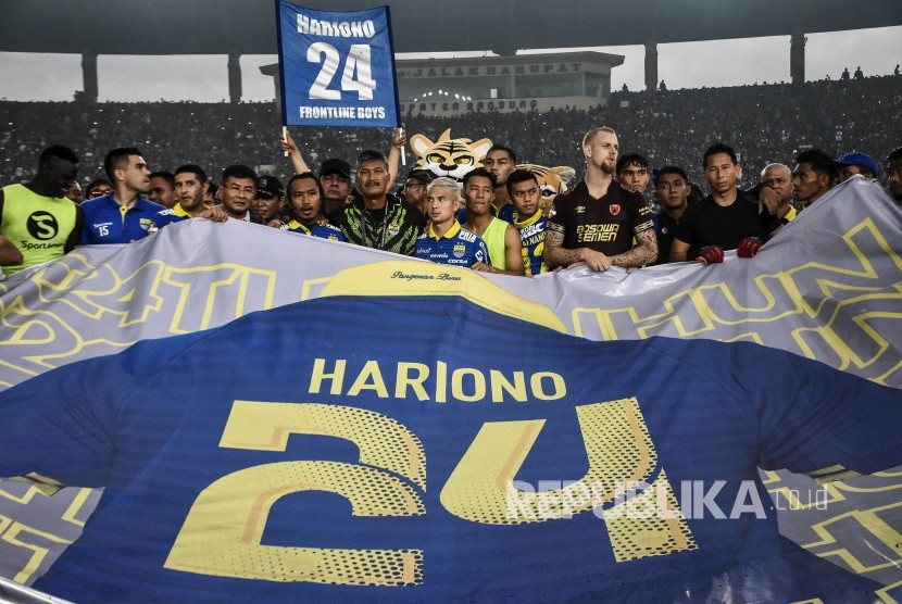 Pemain sekaligus ofisial Persib Bandung membentangkan spanduk raksasa bergambar kostum Hariono saat seremoni perpisahan Hariono usai pertandingan lanjutan Liga 1 2019 melawan PSM Makassar di Stadion Si Jalak Harupat, Kabupaten Bandung, Ahad (22/12).