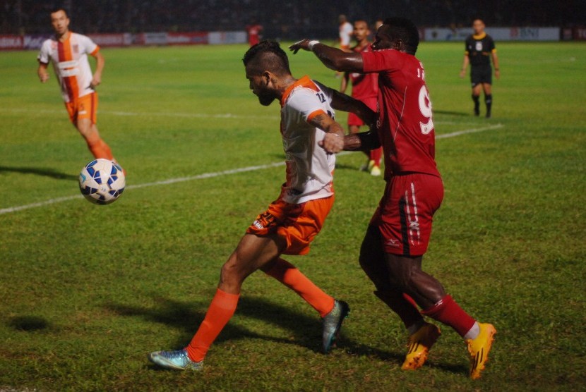 Pemain Semen Padang FC, James Koko Lomel (kanan), berebut bola dengan pemain Pusamania Borneo FC, Diego Michel (kiri), pada baba semifinal leg kedua Turnamen Piala Jenderal Sudirman di Stadion Agus Salim, Padang, Sumatera Barat, Sabtu (16/1). 