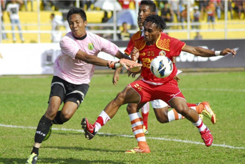 Pemain Semen Padang FC, Titus Bonay (kanan), berebut bola penjaga gawang Persibo Bojonegoro, Ngurah Aria, pada pertandingan Community Shield 2013 di Stadion H. Agus Salim Padang, Sumbar, Minggu (10/2). 