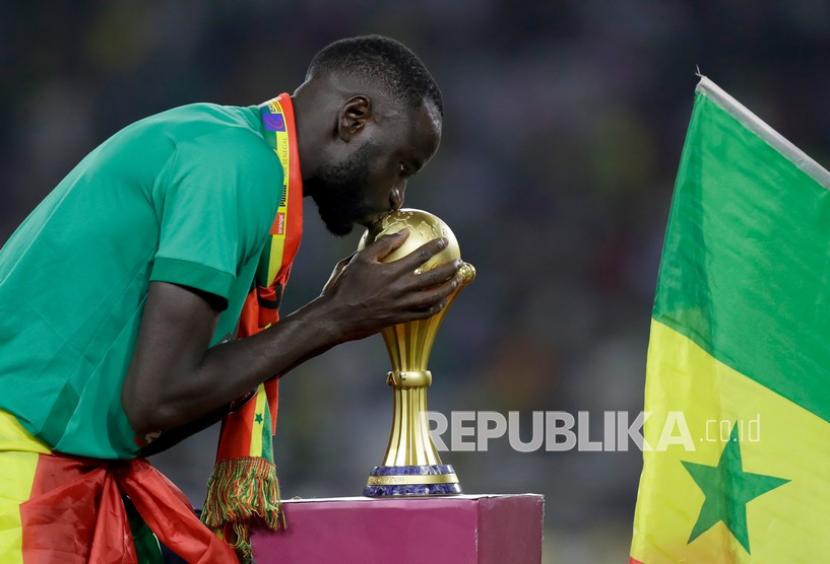  Bek Senegal: Islam Adalah Motivasiku di Piala Dunia 2022. Foto: Pemain Senegal  Cheikhou Kouyate mencium trofi setelah memenangkan pertandingan sepak bola final Piala Afrika 2022 antara Senegal dan Mesir di stadion Ahmadou Ahidjo di Yaounde, Kamerun, Senin (7/2/2022) dini hari WIB.