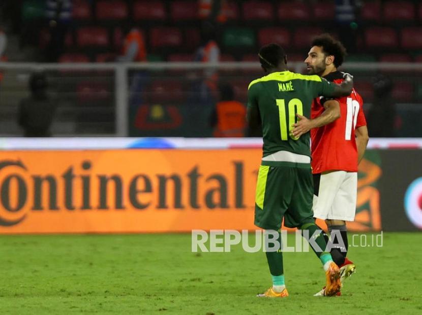 Pemain Senegal Sadio Mane (kiri) dari pemain Mesir Mohamed Salah (kanan) bereaksi setelah final Piala Afrika 2021 antara Senegal dan Mesir di Yaounde, Kamerun, Senin (7/2/2022) dini hari WIB.