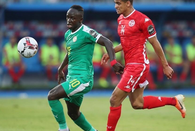 Pemain Senegal Sadio Mane melewati pemain Tunisia saat pertandingan babak Semifinal Piala Afrika, Senin (15/7) dini hari WIB.