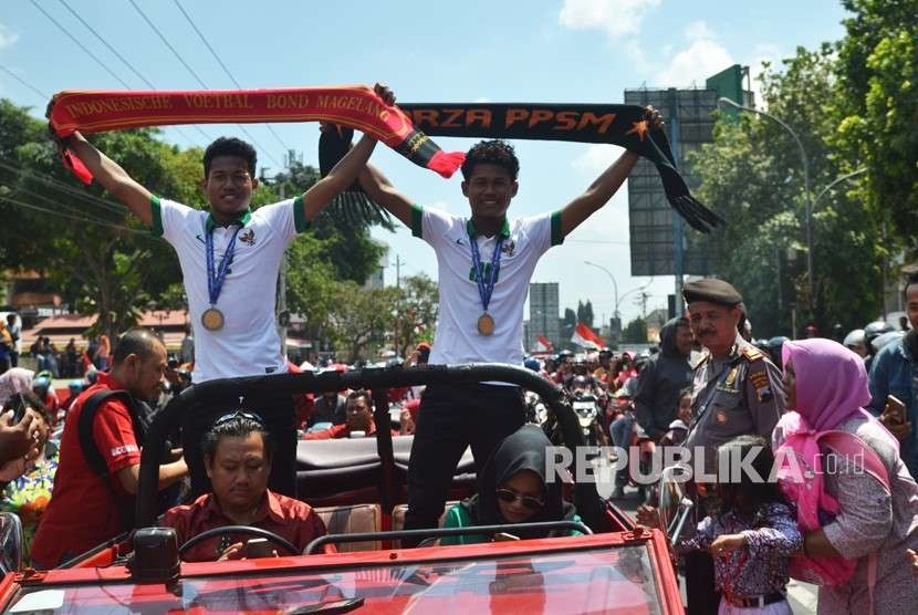 Pemain sepak bola kembar Timnas U-16 Bagas Kaffa (kiri) dan Bagus Kaffi (kanan) menyapa warga saat dikirab keliling Kota Magelang, Jawa Tengah, Rabu (15/8).