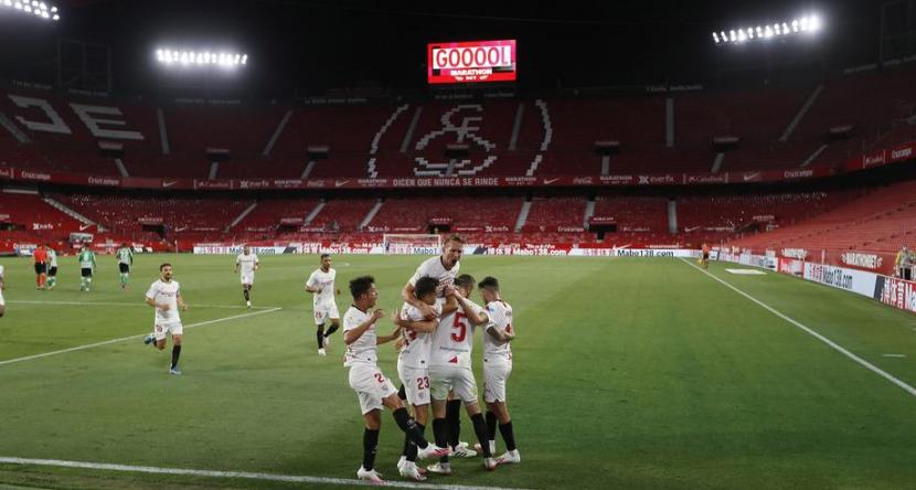 Pemain Sevilla melakukan seleberasi usai mencetak gol. Pada laga perdana La Liga usai ditangguhkan, Sevilla mengalahkan Real Betis 2-0.