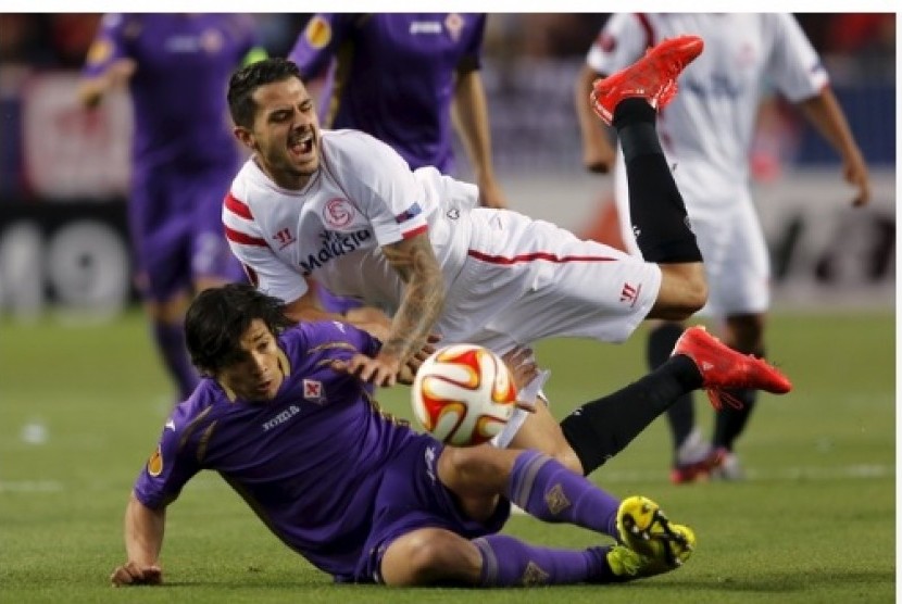 Pemain Sevilla Victor 'Vitolo' Machin (putih) jatuh di samping pemain Fiorentina Matias Fernandez dalam leg pertama semifinal Liga Europa di Ramon Sanchez Pizjuan, Jumat (8/5) WIB.