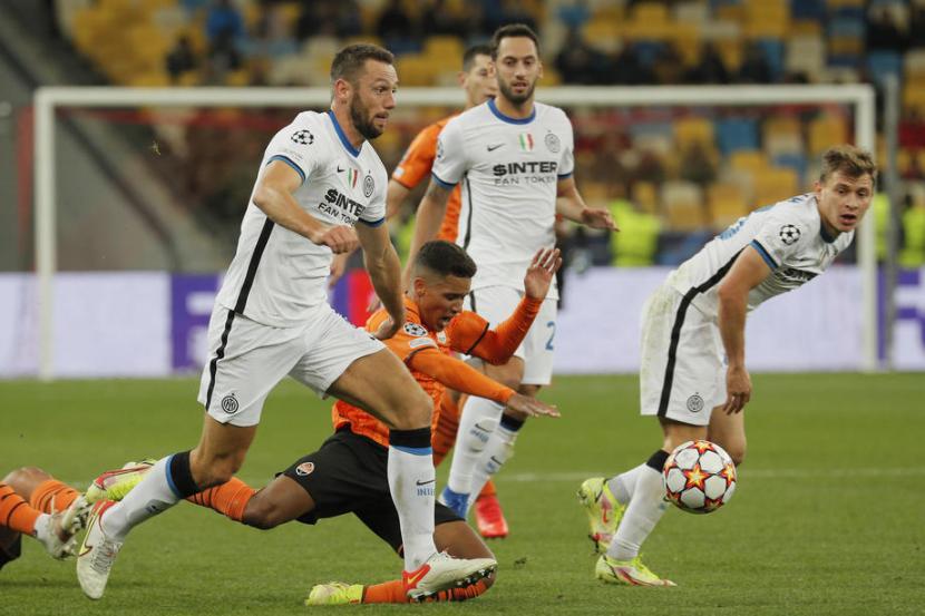 Pemain Shakhtar Donetsk Pedrinho terjatuh saat berusaha merebut bola dari bek Inter Milan Stefan de Vrij dalam pertandingan Grup D di Kiev, Ukraine, Rabu (29/9) dini hari WIB. 