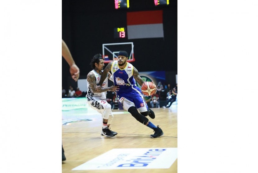 Pemain SM Pertamina Jamar Andre Johnson dijaga pemain BSB Hangtuah Kelly Purwanto dalam gim pertama semifinal divisi merah IBL Pertaliate 2017/2018