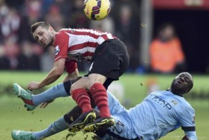 Pemain Southampton Morgan Schneiderlin (kiri) berjibaku dengan gelandang Manchester City Yaya Toure dalam pertandingan Liga Primer Inggris, Ahad (30/11).