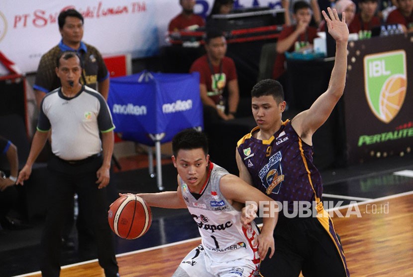 Pemain Stapac Jakarta, Andakara Prastawa menguasai bola,  dibayangi pemain Satya Wacana Salatiga. Dalam pertandingan pertama IBL Pertalite Seri-7 Cirebon, Jumat (2/2) di GOR GMC Cirebon, Stapac menang besar 103-66.  