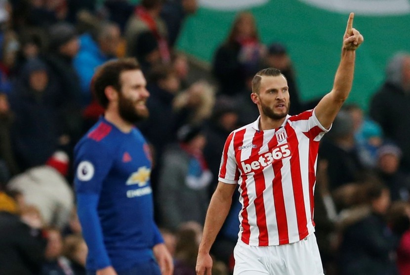 Pemain Stoke City, Erik Pieters (kiri) merayakan gol bunuh diri yang dibuat gelandang Manchester United, Juan Mata (kanan) pada laga Liga Primer di stadion Bet365, Sabtu (21/1). United tertinggal satu gol pada babak pertama.