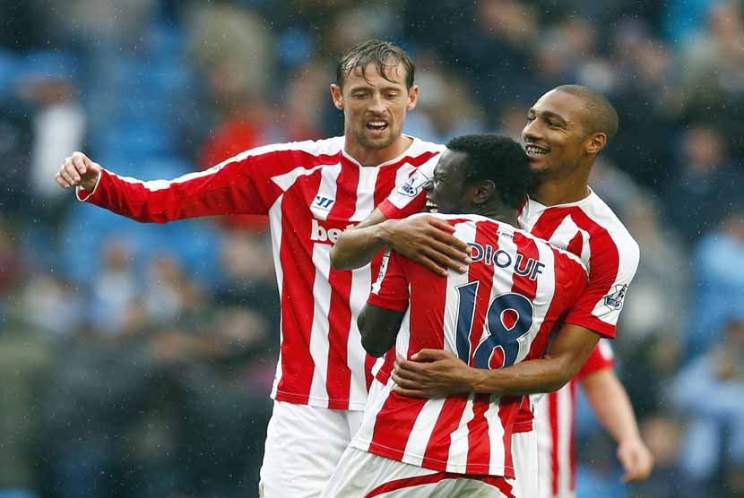 Pemain Stoke City, Mame Diouf (tengah), melakukan selebrasi bersama dua rekannya Peter Crouch (kiri) dan Steven N'Zonzi (kanan) usai menjebol gawang Manchester City di laga Liga Primer Inggris di Etihad stadium, Manchester, Sabtu (30/8). 