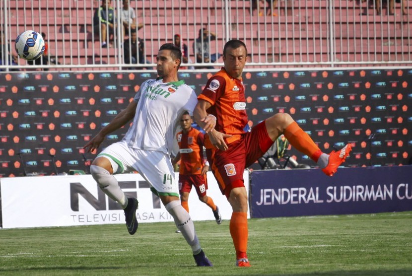 Pemain Pusamania Borneo FC, Goran Gancev (kanan) berebut bola dengan pemain Surabaya United, Pedro Javier Valasques saat laga Piala Jenderal Sudirman di Stadion Maguwoharjo, Sleman, Yogyakarta, Ahad (13/12). 