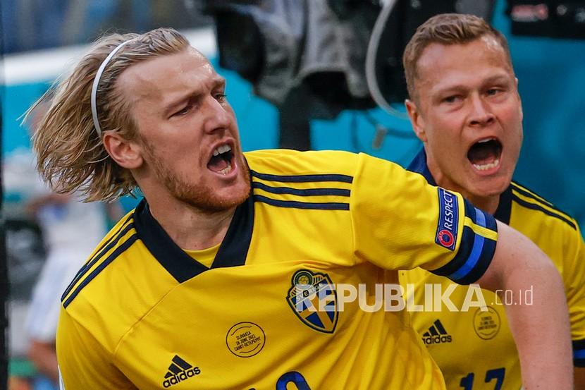Pemain Swedia Emil Forsberg (kiri) merayakan dengan rekan setimnya Viktor Claesson setelah mencetak gol pembuka timnya pada pertandingan grup E kejuaraan sepak bola Euro 2020 antara Swedia dan Slovakia, di stadion Saint Petersburg, di Saint Petersburg, Rusia, Jumat (18/6).
