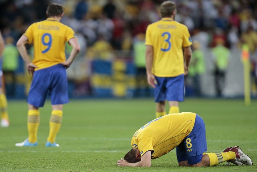  Pemain Swedia tertunduk lesu usai ditaklukan tim Inggris dalam laga penyisihan Grup D di Stadion Olimpiade Kyiv, Ukraina, Jumat (15/6). (Ivan Sekretarev/AP)