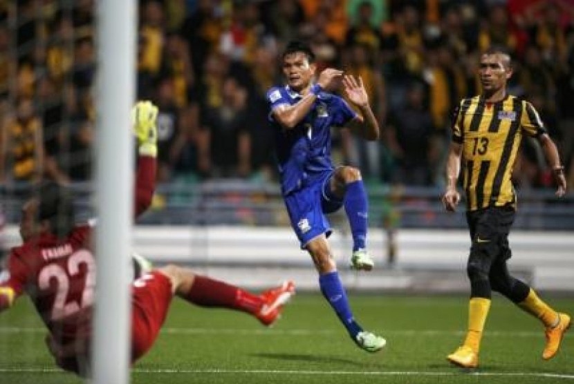 Pemain Thailand Adisak Kraisorn mencetak gol ke gawang Malaysia dalam pertandingan Grup B di Stadion Jalan Besar, Singapura, Rabu (26/11).