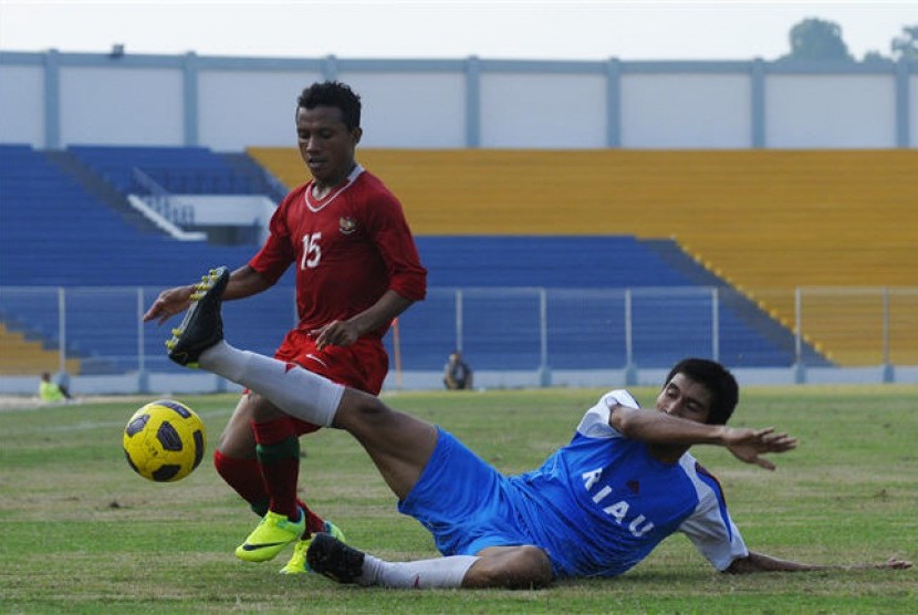 Pemain Tim Nasional Indonesia U-22, Bayau (kiri), berebut bola dengan pemain Tim Sepakbaola PON Riau, Cecep Arifin (kanan), saat pertandingan laga uji coba di Stadion Kaharudin Nasution Rumbai, Pekanbaru, Riau, (30/6). 