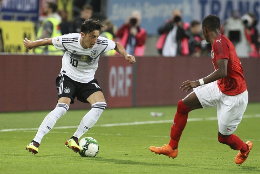 Pemain tim nasional Jerman Mesut Ozil (kiri) mencoba membawa bola dari adangan pemain Austria David Alaba dalam laga persahabatan yang berlangsung di Klagenfurt, Austria, Sabtu (2/6). 