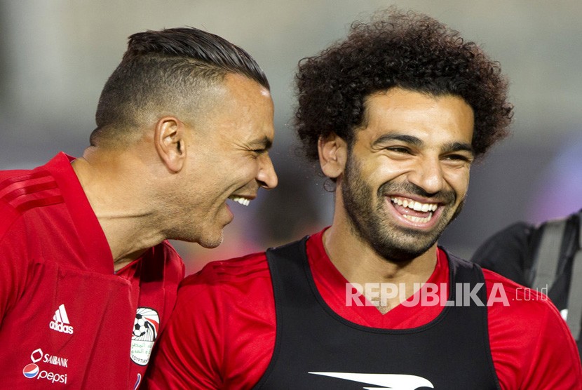 Pemain tim nasional  Mesir dan striker bintang Liverpool Mohammed Salah berbagi tawa dengan kiper Essam El Hadary selama latihan terakhir Mesir untuk turnamen sepak bola Piala Dunia, di Stadion Kairo di Kairo, Mesir, Sabtu (9/6). 