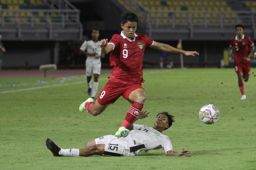 Pemain tim U-20 Indonesia Hokky Caraka Brilliant (atas) melewati hadangan pemain tim U-20 Timor-Leste Willian Quintas Vong saat pertandingan kualifikasi Piala Asia U-20 2023 Grup F di Stadion Gelora Bung Tomo, Surabaya, Jawa Timur, Rabu (14/9/2022). 