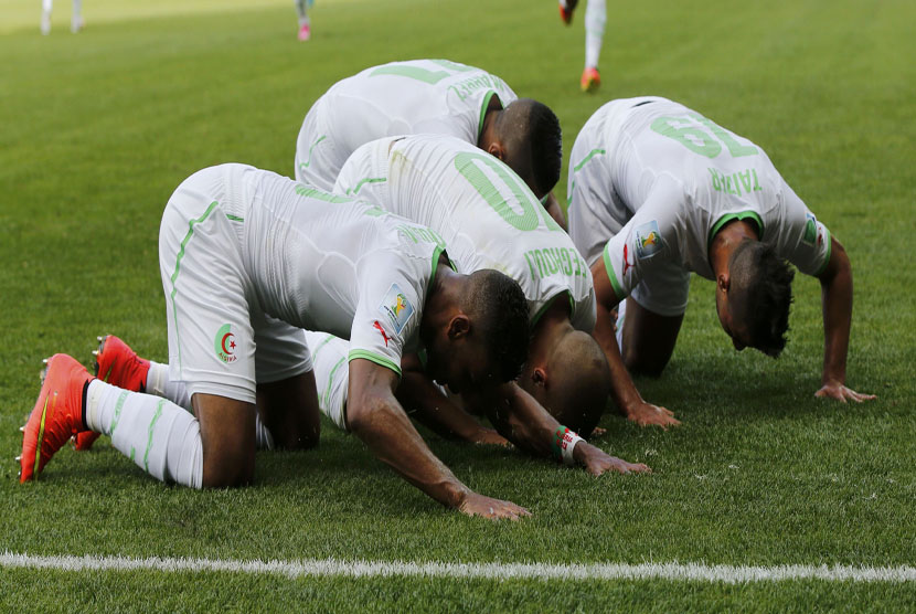 Pemain Timnas Aljazair, Sofiane Feghouli, melakukan selebrasi sujud syukur usai menjebol gawang Belgia di laga Grup H Piala Dunia 2014 Brasil di Stadion Mineiroa, Belo Horizonte, Selasa (17/6). 