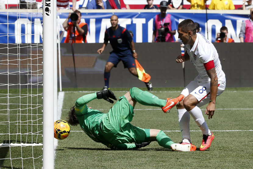 Pemain timnas Amerika Serikat, Clint Dempsey (kanan), menceploskan bola ke gawang kiper timnas Turki, Onur Recep Kivrak, dalam laga internasional di Harrison, New Jersey, Ahad (1/6). 