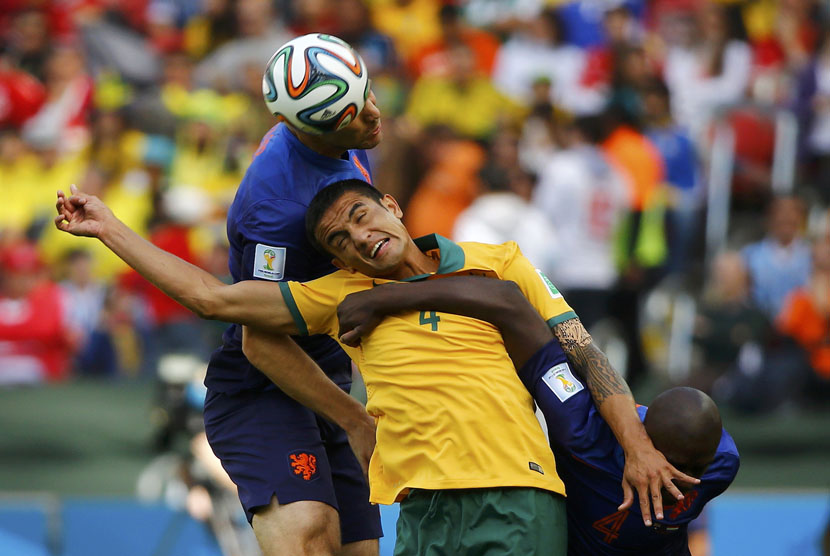 Pemain Timnas Belanda, Ron Vlaar (kiri) dan Bruno Martins Indi, berebut bola dengan pemain Australia, Tim Cahill (tengah), dalam laga Grup B Piala Dunia 2014 Brasil di Stadion Beira Rio, Porto Alegre, Rabu (18/6). 