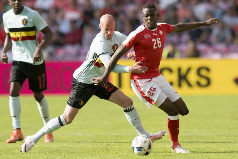 Pemain Timnas Belgia, Laurent Caiman (kiri), berebut bola dengan pemain Swiss, Denis Zakaria, dalam laga internasional di Jenewa, Swiss, pada 28 Mei 2016. 
