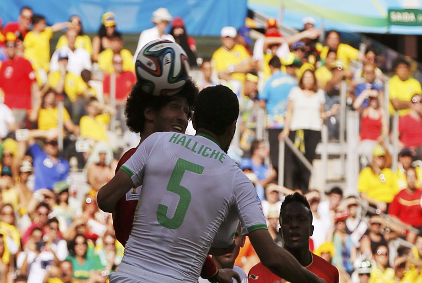 Pemain Timnas Belgia, Marouane Fellaini (kiri), melepaskan sundulan menjebol gawang Aljazair di laga Grup H Piala Dunia 2014 Brasil di Stadion Mineirao, Belo Horizonte, Selasa (17/6). 