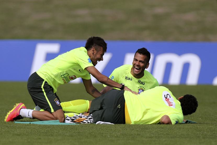 Pemain Timnas Brasil, Neymar (kiri) dan Dani Alves (tengah), bercand di sela sesi latihan di Teresopolis, Rio de Janeiro, Ahd (1/6). 