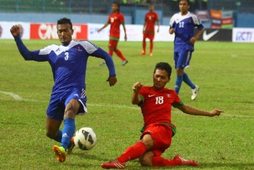 Pemain timnas Indonesia, Anindito Wahyu (kanan) berebut bola dengan pemain Nepal, Biraj Maharian.