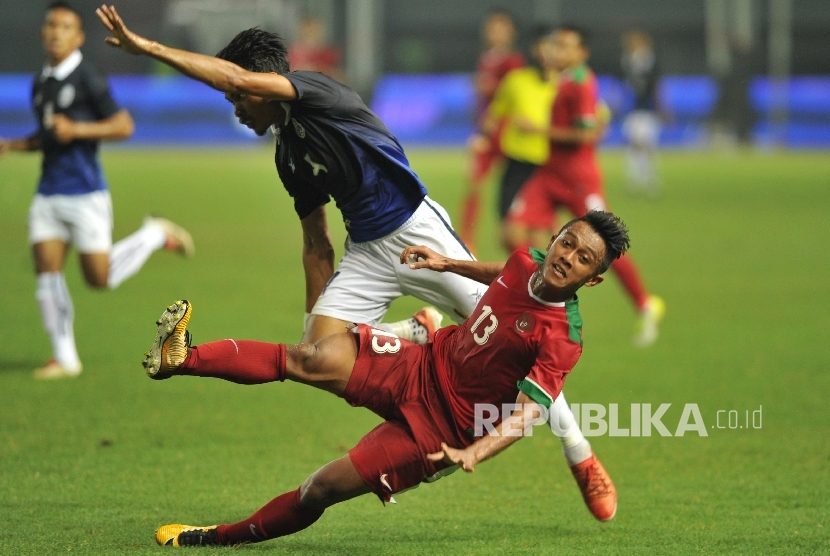 Pemain timnas Indonesia Febri Haryadi terjatuh seusai berebut bola dengan pemain lawan dalam laga uji coba melawan Kamboja di Stadion Patriot Chandrabhaga, Bekasi, Rabu (4/10).