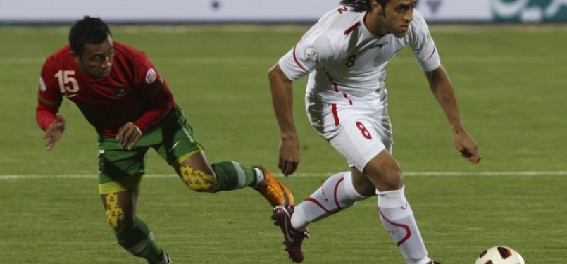 Pemain Timnas Indonesia, Firman Utina (kanan), dan pemain Timnas Iran Ali Karimi (Kiri) berjibaku menguasai lapangan tengah dalam pertandingan kualifikasi Grup E Asia Pra Piala Dunia, Jumat malam di Teheran. Iran menang telak 3-0.