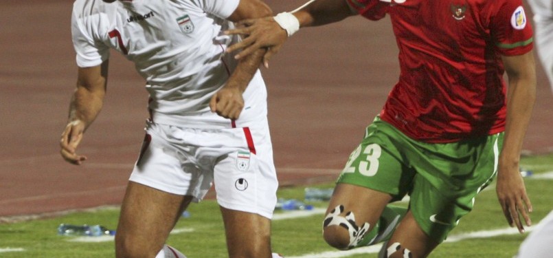 Pemain Timnas Indonesia, Hamka (kanan), dan pemain Timnas Iran Farhad Majidi (kiri) berebut bola dalam pertandingan kualifikasi Grup E Asia Pra Piala Dunia di Teheran, Jumat malam. Iran menang telak 3-0.