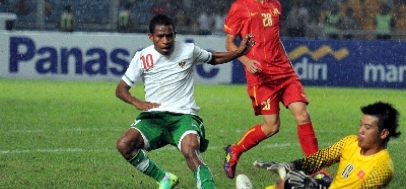 Pemain Timnas Indonesia, Oktovianus Maniani (kiri), mengejar bola dengan pemain Vietnam saat pertandingan semifinal SEA Games ke-26 di Stadion Utama Gelora Bung Karno, Jakarta, Sabtu (19/11) malam.