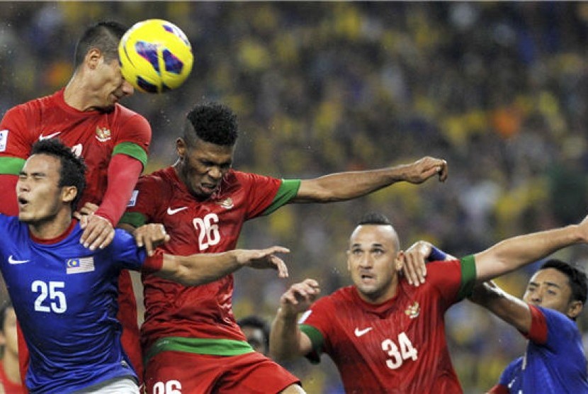 Pemain timnas Indonesia, Raphael Maitimo (kiri atas), terlibat duel udara dengan pemain Malaysia, Wan Zack Haikal (kiri bawah), pada pertandingan babak penyisihan grup B Piala AFF 2012 di stadion Bukit Jalil, Kuala Lumpur, Malaysia, Sabtu (1/12). 