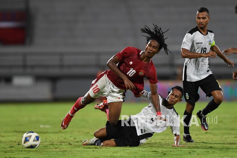 Pemain timnas Indonesia Ronaldo Kwateh (kiri) diadang oleh pemain Timnas Timor Leste Orcelio Nobelito dalam pertandingan sepak bola Leg 1 FIFA Matchday di Stadion I Wayan Dipta, Gianyar, Bali, Kamis (27/1/2022). Indonesia menang atas Timor Leste dengan skor 4-1.