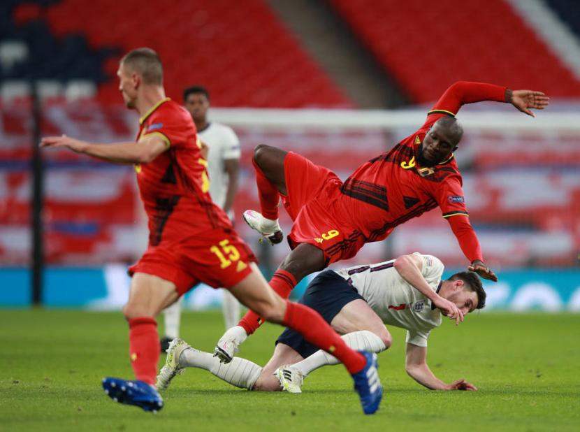 Pemain timnas Inggris Declan Rice (kanan bawah) terjatuh saat berjibaku dengan penyerang Belgia Romelu Lukaku.