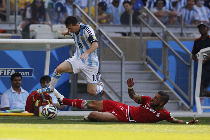 Pemain Timnas Iran, Ashkan Dejagah (kanan), berebut bola dengan striker Argentina, Lionel Messi, di laga Grup F Piala Dunia 2014 Brasil di Stadion Mineirao, Belo Horizonte, Sabtu (21/6). 