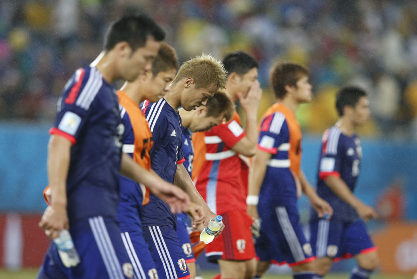 Pemain Timnas Jepang berjalan meninggalkan lapanga usai gagal mengalahkan Yunani di laga Grup C Piala Dunia 2014 di Arena Dunas, Natal, Kamis (19/6). 