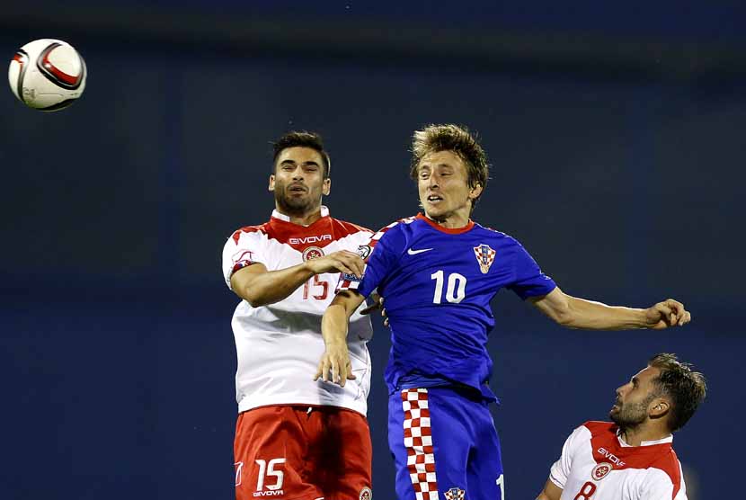 Pemain Timnas Kroasia, Luka Modric (tengah), terlibat duel udara dengan pemain Timnas Malta dalam laga kualifikasi Piala Eropa 2016 di Zagreb, Kroasia, Selasa (9/9). 