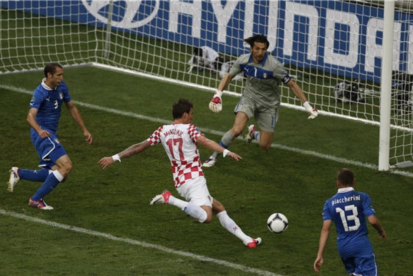  Pemain timnas Kroasia, Mario Mandzukic (tengah), melepaskan tembakan menggol gawang Italia di laga Grup C Piala Eropa 2012 di Poznan, Polandia, pada Kamis (14/6).